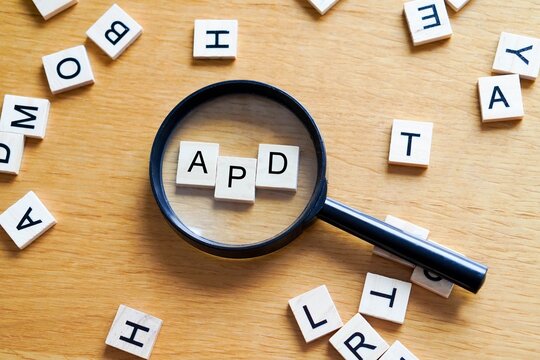 APD, mental health and medicine concepts. Wooden letters with a magnifying glass on a wooden background