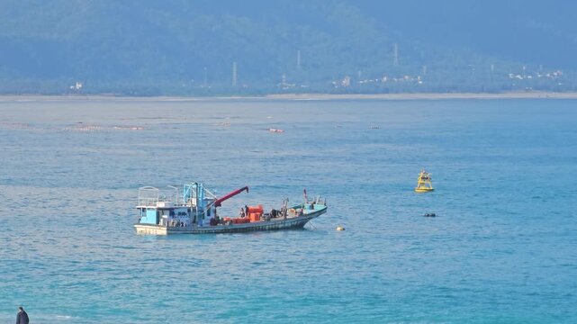Small working fishing boats and utility vessels anchored along Hualien coastline, calm blue waters and traditional maritime livelihood scene under clear coastal sky in eastern Taiwan