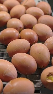 Boiled balut eggs displayed on metal rack at traditional street food market close up eggs arranged on wire rack at authentic street food stall ready to eat