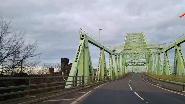 Driving POV under the Runcorn Jubilee green bridge crossing into Widne