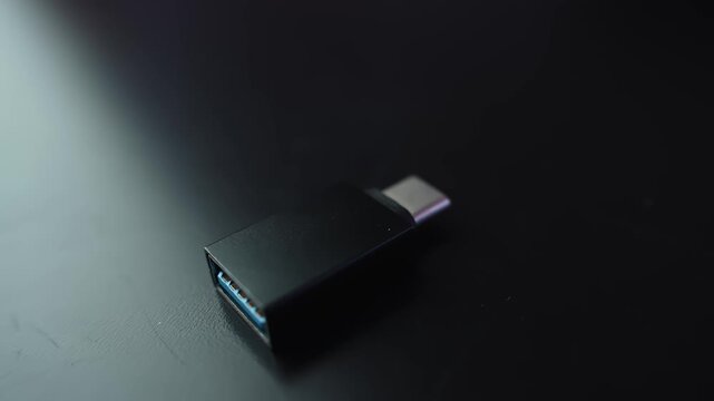 Macro close-up of a USB-A 3.0 to USB-C adapter on a dark desk with shallow depth of field and copy space, ideal for tech, connectivity, and device compatibility visuals.