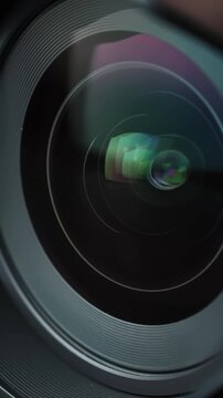 Extreme macro of a camera lens as aperture blades open, revealing colorful reflections in the glass. Ideal tech b-roll for photography, filmmaking, and gadget ads.