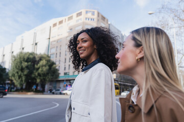 Fototapeta premium Young women friends smiling walking together in city