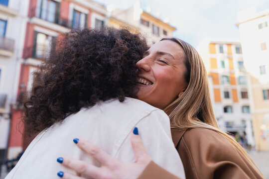 Young women friends embracing with feeling and connection