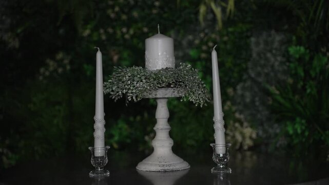 Atmospheric wedding venue setup with elegant table settings, glowing candles, and decorative lanterns creating a warm and romantic ambiance. Beautiful reception d cor prepared for guests, cozy evening