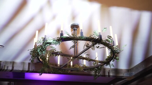 Atmospheric wedding venue setup with elegant table settings, glowing candles, and decorative lanterns creating a warm and romantic ambiance. Beautiful reception d cor prepared for guests, cozy evening