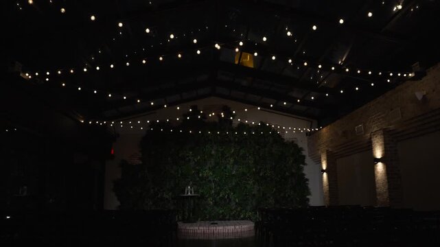 Atmospheric wedding venue setup with elegant table settings, glowing candles, and decorative lanterns creating a warm and romantic ambiance. Beautiful reception d cor prepared for guests, cozy evening