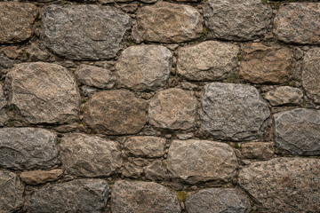 Obraz premium A close-up of a textured stone wall composed of various sized rocks.