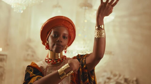 Fabulous african princess dancing in her place, medium portrait, look at camera. Arabian fairytale and cultural traditions of africa, gold bracelets on female hands, jewelry store, ethnic collection