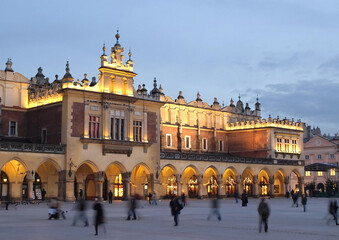 Naklejka premium The Cloth Hall (Sukiennice) in Krakow beautifully illuminated at night with a deep blue twilight sky. Masterpiece of Renaissance architecture on the Main Market Square.