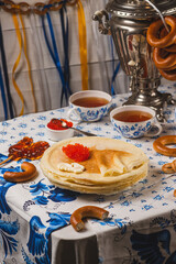 Pancakes on the table next to the samovar and caviar