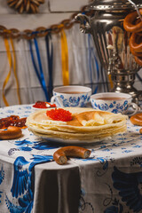 Pancakes on the table next to the samovar and caviar