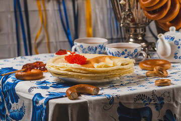 Pancakes on the table next to the samovar and caviar