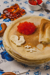 Pancakes on the table next to the samovar and caviar