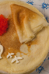 Pancakes on the table next to the samovar and caviar