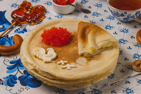 Pancakes on the table next to the samovar and caviar