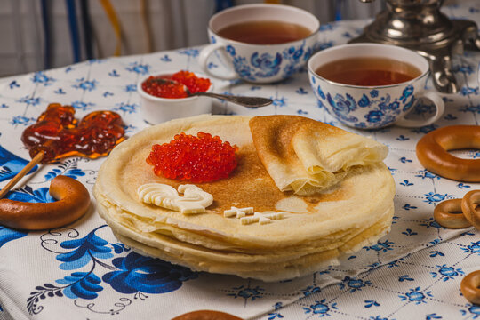 Pancakes on the table next to the samovar and caviar