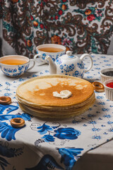 Pancakes on the table next to the samovar and caviar