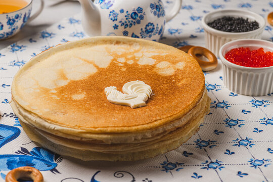 Pancakes on the table next to the samovar and caviar