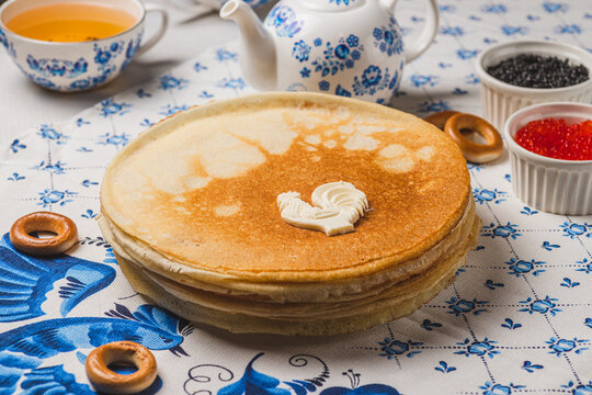Pancakes on the table next to the samovar and caviar