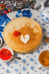 Pancakes on the table next to the samovar and caviar