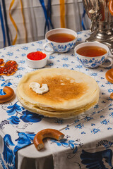 Pancakes on the table next to the samovar and caviar