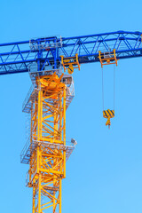 Naklejka premium Tower crane against clear blue sky at construction site