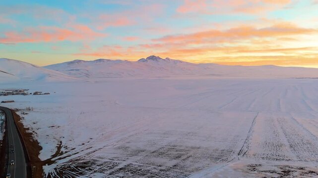 Dramatic Fiery Sunset Over Snowy Mountain Landscape &ndash; Aerial Drone View, Mount Aragats is visible from the valley