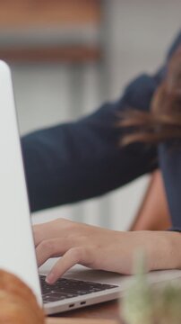 Vertical Screen : Young Asian business women working on laptop at coffee shop. Asia happy girl barista waiter wear gray apon serve hot cup of coffee to female customer who business work in cafe.