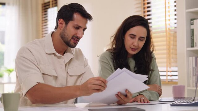Couple overwhelmed by overdue bills and low income, facing economic stress and inflation-related financial crisis