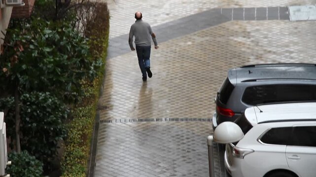 Corriendo bajo la lluvia con prisa para protegerse del agua