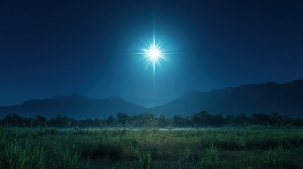Night landscape with a brilliant celestial light over a field, mountains in background