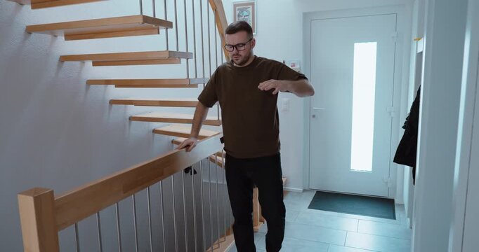 Indoor scene of a man holding onto a railing while experiencing dizziness and near circulatory collapse. Concept of vertigo, fainting risk, health emergency and sudden medical episode at home.