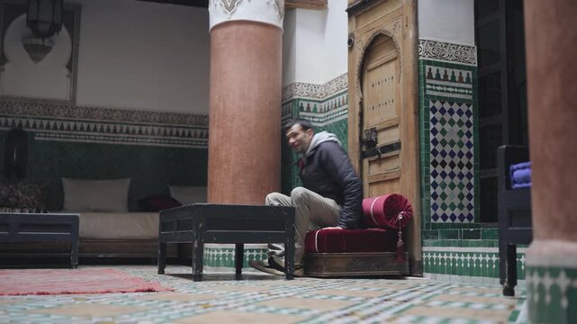 Man walking through traditional Moroccan riad courtyard