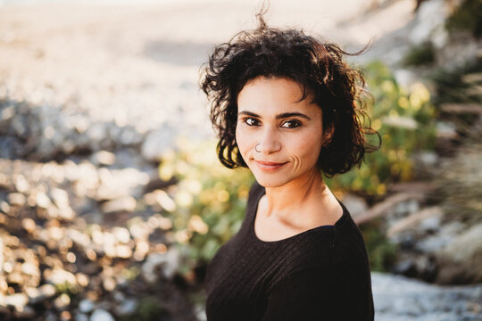 Beautiful hispanic woman nose piercing wavy hair at beach