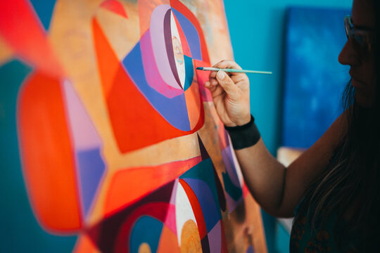 Close up of female artist hand painting eccentric modern painting