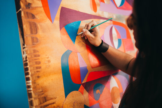 Close up of female artist hand painting eccentric modern painting