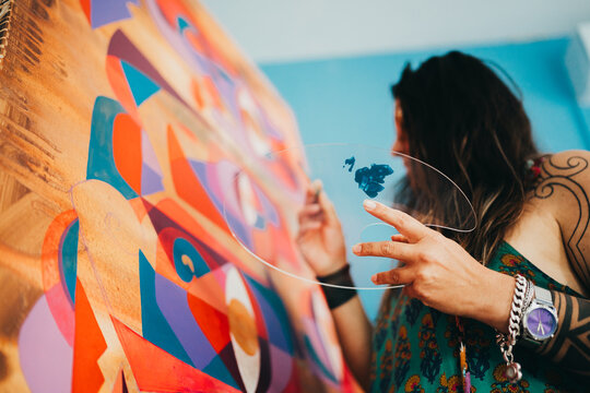 Close up of female artist hand painting eccentric modern painting