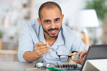 Obraz premium man reapiring a pair of spectacles