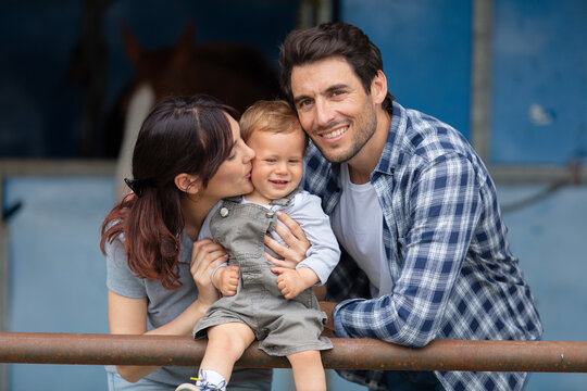 cheerful young family working at a farm