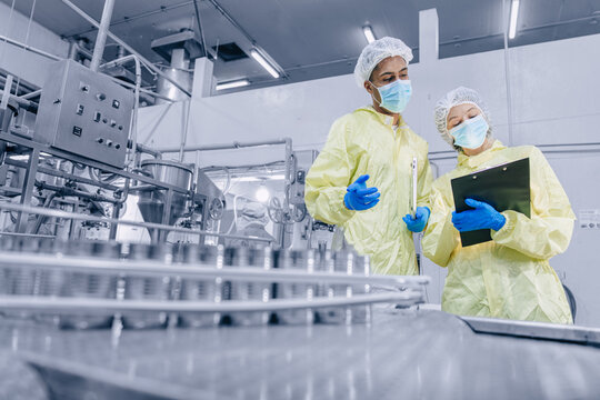 Food cannery industry hygiene worker check tin can for food product container, Canned food factory
