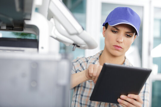 pretty technician using digital tablet while carrying out inspection