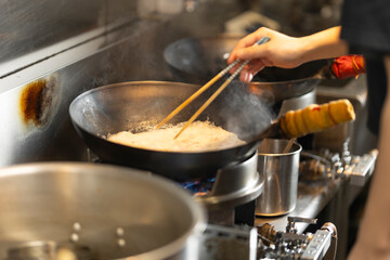 Chef Preparing Ramen in Japanese Noodle Shop with Steam Rising