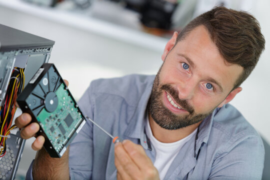 male repairman trying to fix a computer