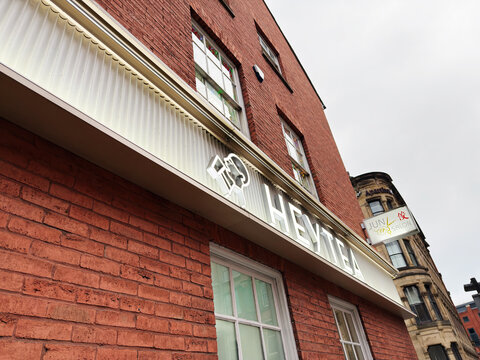 Brick Heytea on a city street in Manchester, UK with signage and red brick facade