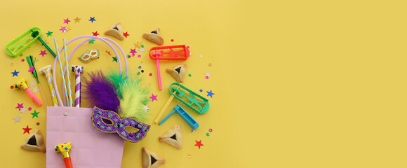 Purim celebration concept (jewish carnival holiday) over yellow background