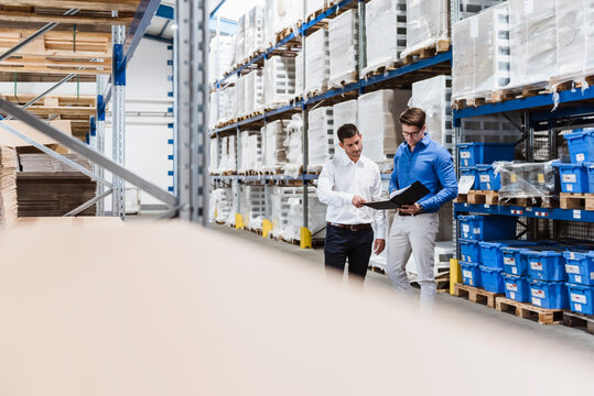 Two businessmen having a meeting in company warehouse