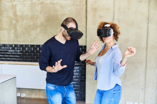 Man and woman wearing VR glasses moving