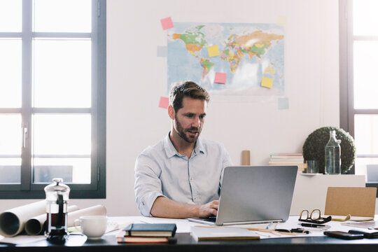 Architect working on laptop at desk in his office