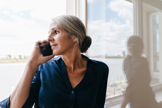 Businesswoman on the phone at the window